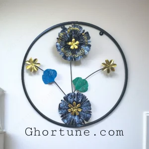 Round Metal Floral Wall Decor with blue and black flowers and gold centers inside a black frame.