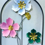 Close-up of Pastel Floral Metal Wall Decor showing light blue, pink, and green metal flowers with gold centers.