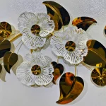 Close-up of High Quality white layered flowers and shiny gold/black leaves on the metal wall art.
