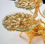 Beautiful gold 3-tier serving stand on a wooden table, holding colorful candy, showing it being used as a luxury candy dish.